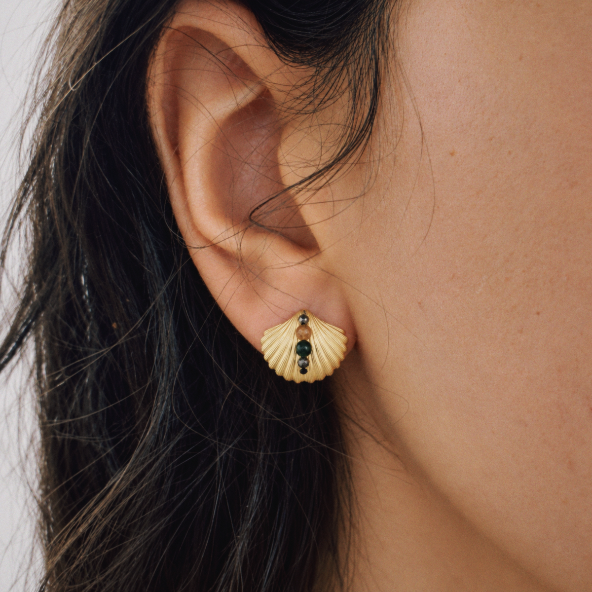 Model wearing Lil Cacti seashell stud earrings in a close detail view