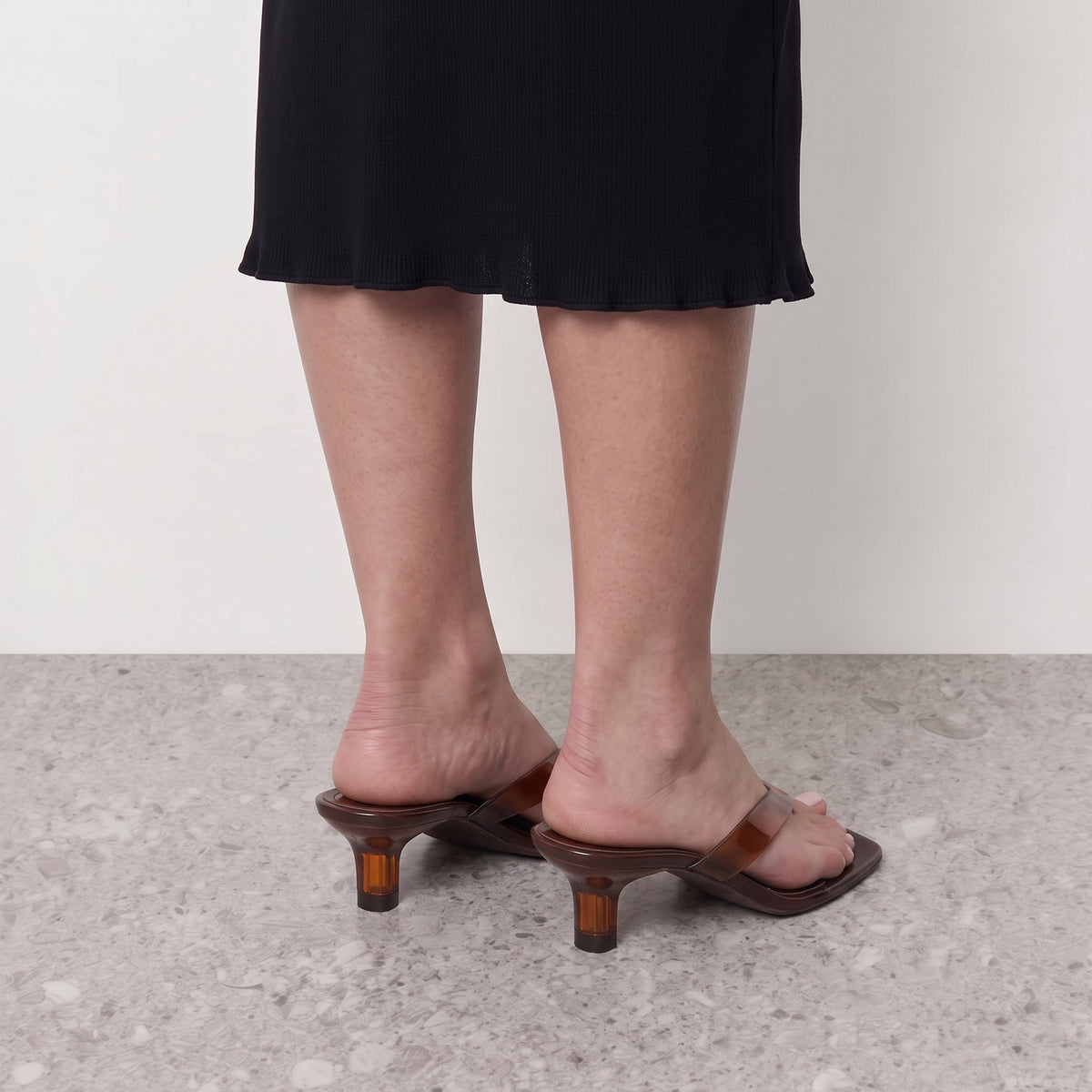 Model standing in Lil Cacti Mirage thong sandals on a stone floor