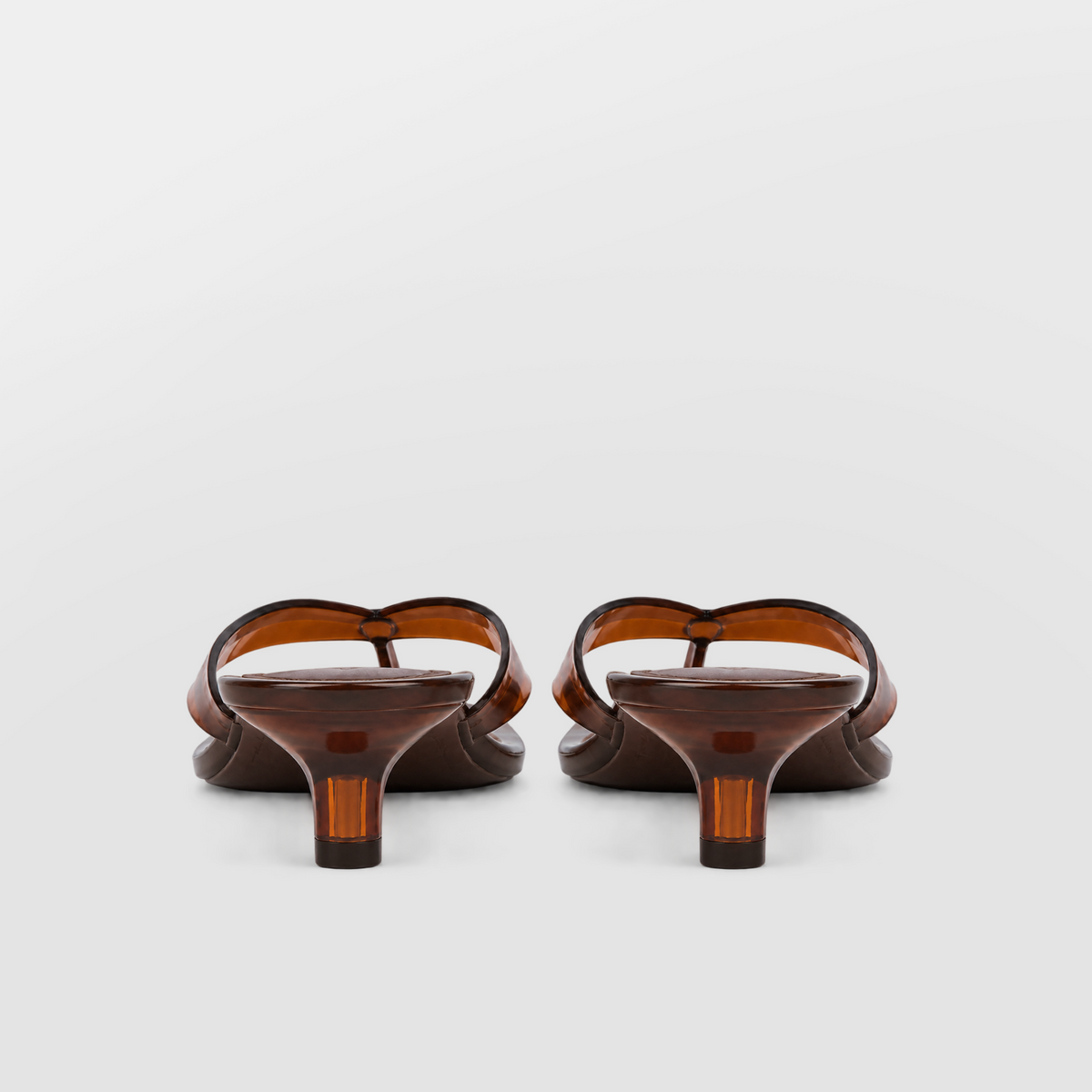 Mirage Thong Sandals by Lil Cacti — back view of brown pair showing flared translucent amber kitten heels