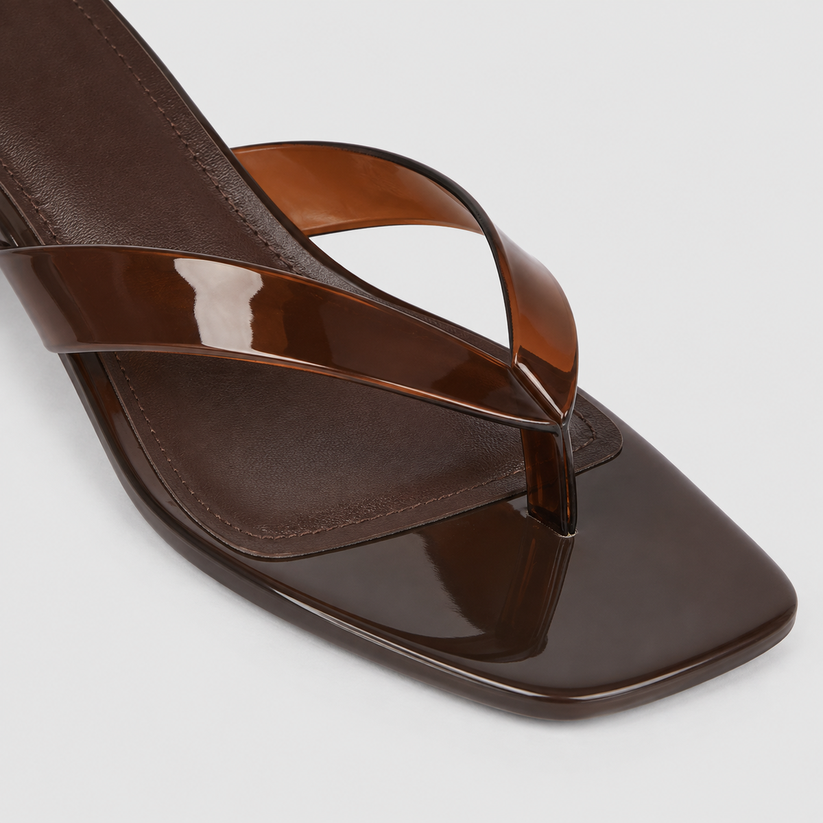 Mirage Thong Sandals by Lil Cacti — close-up of brown glossy translucent thong strap, toe post and square toe
