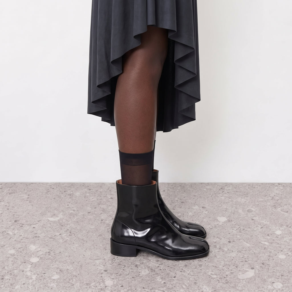 Model wearing Nadia black tabi Chelsea boots with sheer ankle socks
