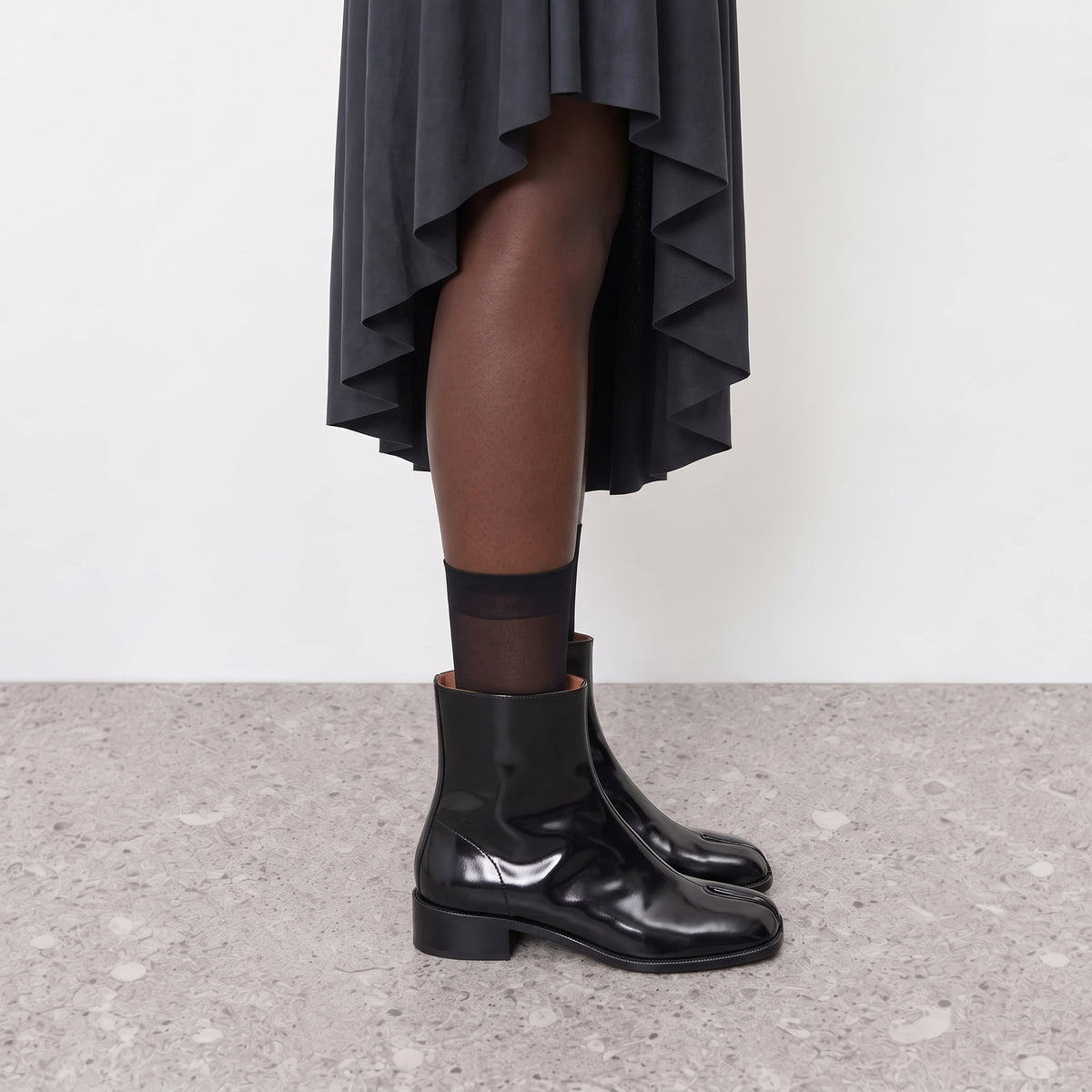 Model wearing Nadia black tabi Chelsea boots with sheer ankle socks
