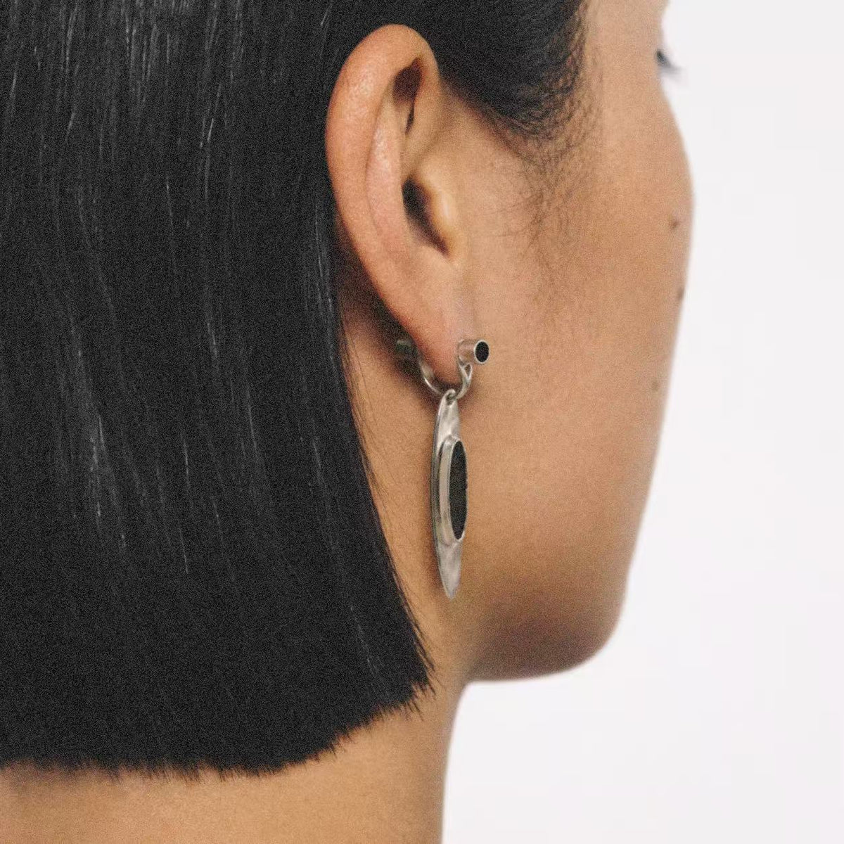 Model wearing the Oval Stone Drop Earrings in a close crop
