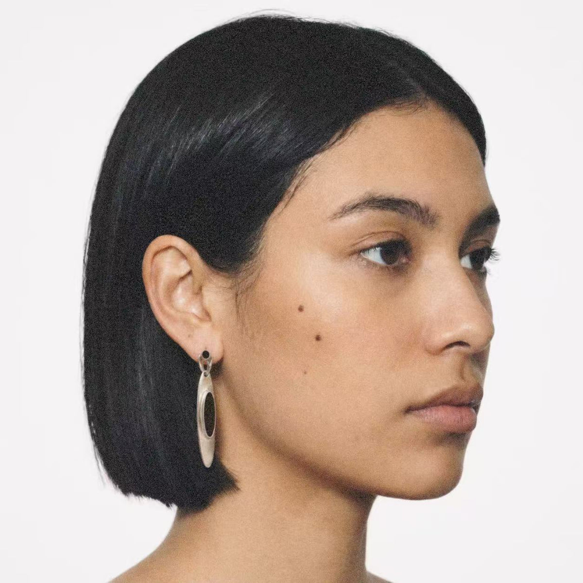 Model wearing the Oval Stone Drop Earrings in a relaxed pose