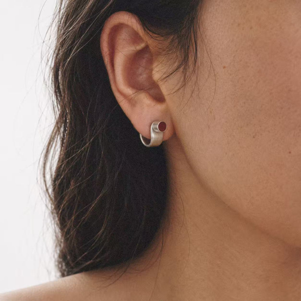 Model wearing the Pebble Disc Huggie Earrings seen from the front