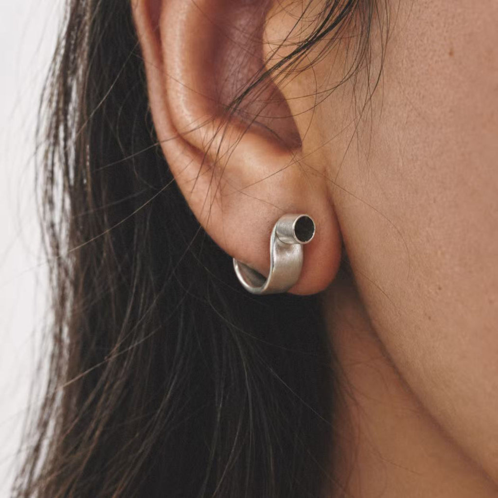 Model wearing the Pebble Disc Huggie Earrings seen from behind