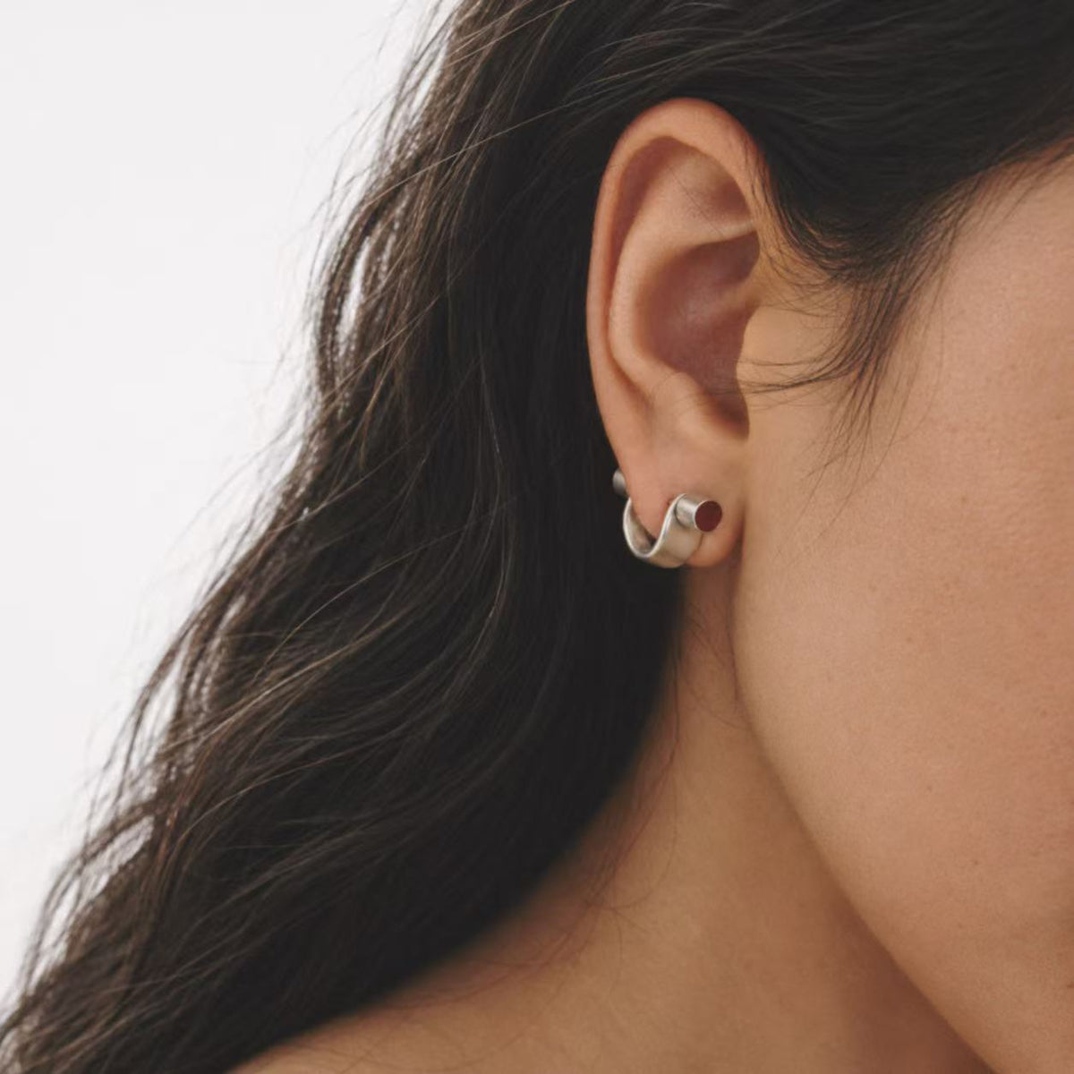 Model wearing the Pebble Disc Huggie Earrings in a close crop