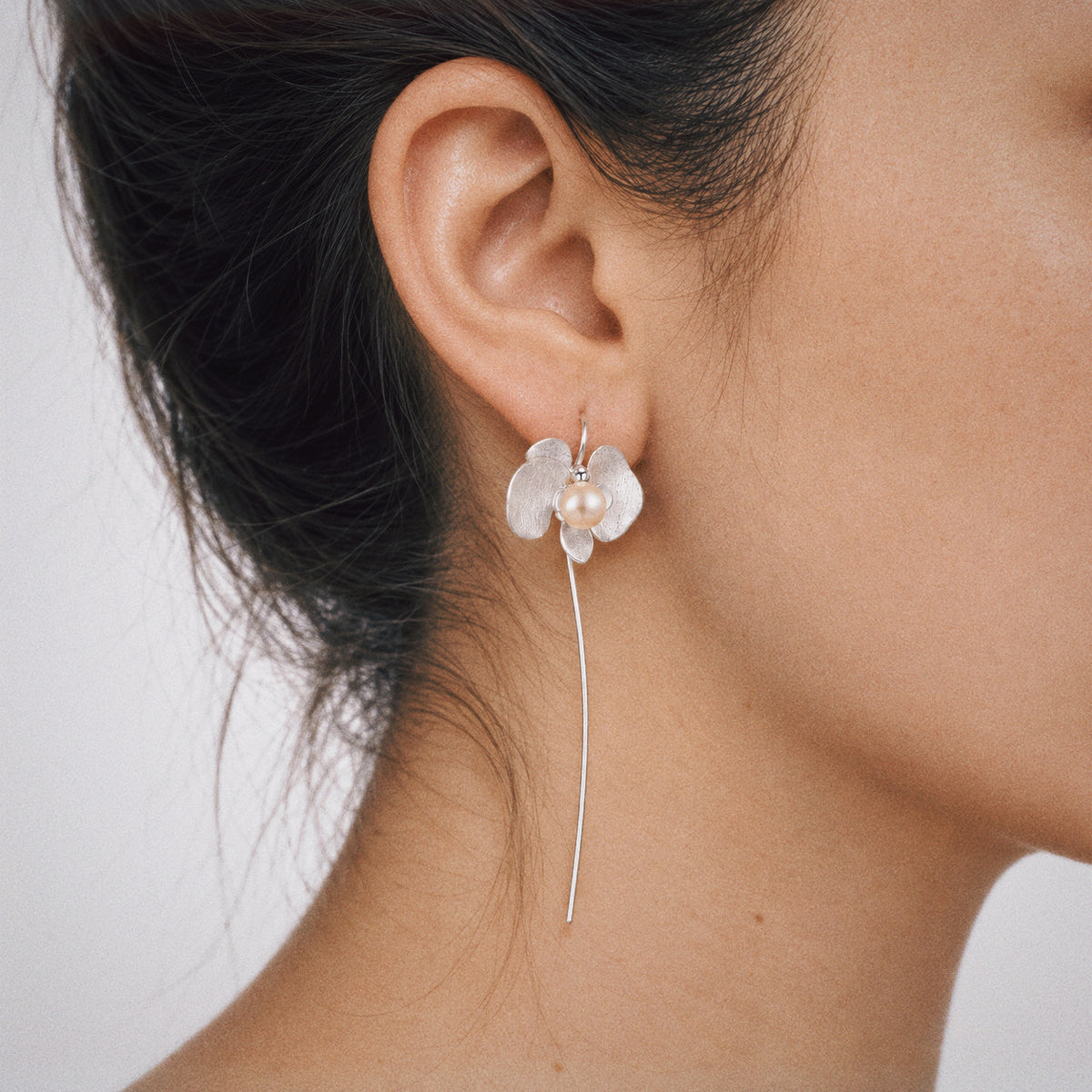Close-up of the Petal Orchid Drop Earrings, showing the finish and shape up close