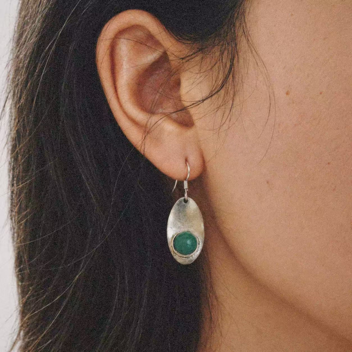 Relic Green Stone Drop Earrings worn on the ear, green stone earrings