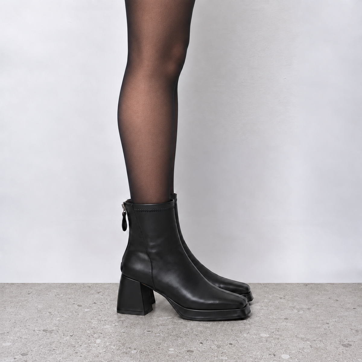 Model wearing Risa Square-Toe Chunky Heel Ankle Boots in black, full-length product styling view