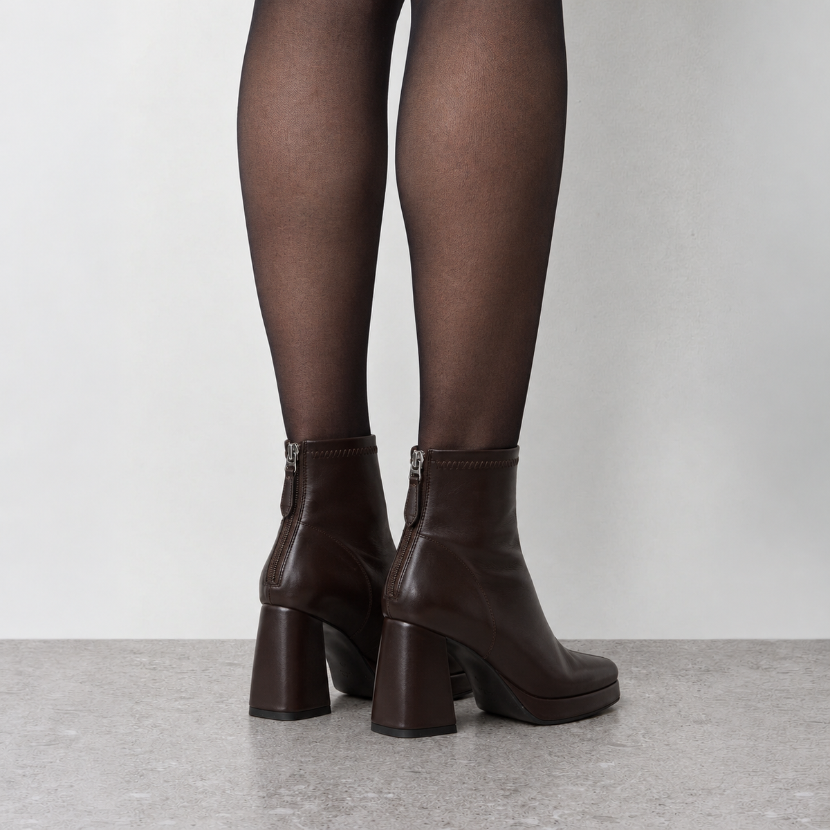 Model wearing Risa Square-Toe Chunky Heel Ankle Boots in brown, close on-foot styling detail