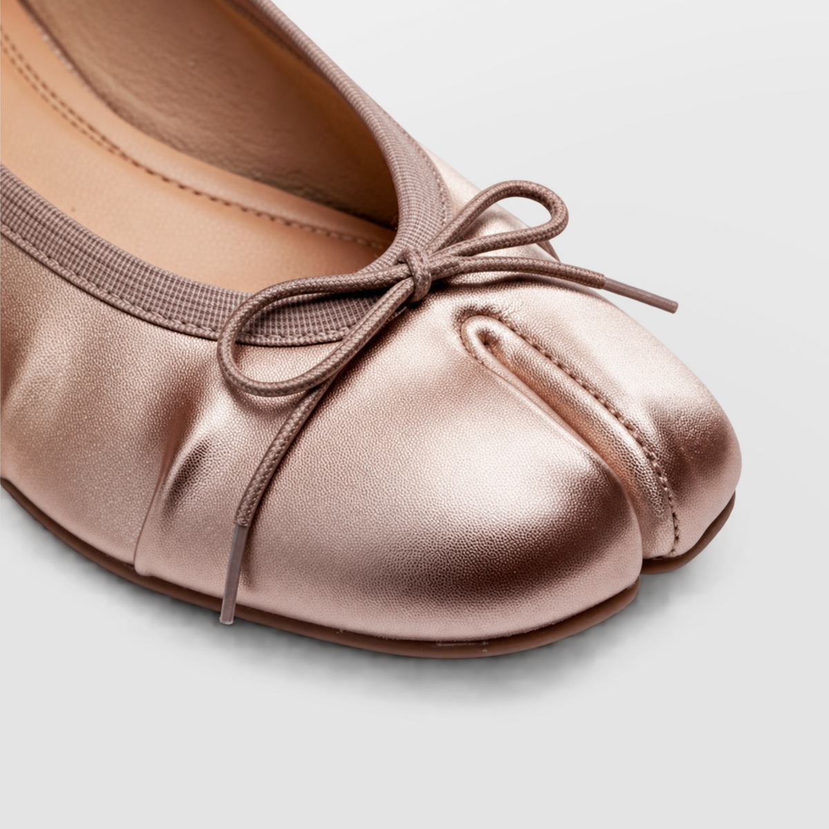 Close crop of the knotted bow and split toe on a Lil Cacti champagne tabi pump