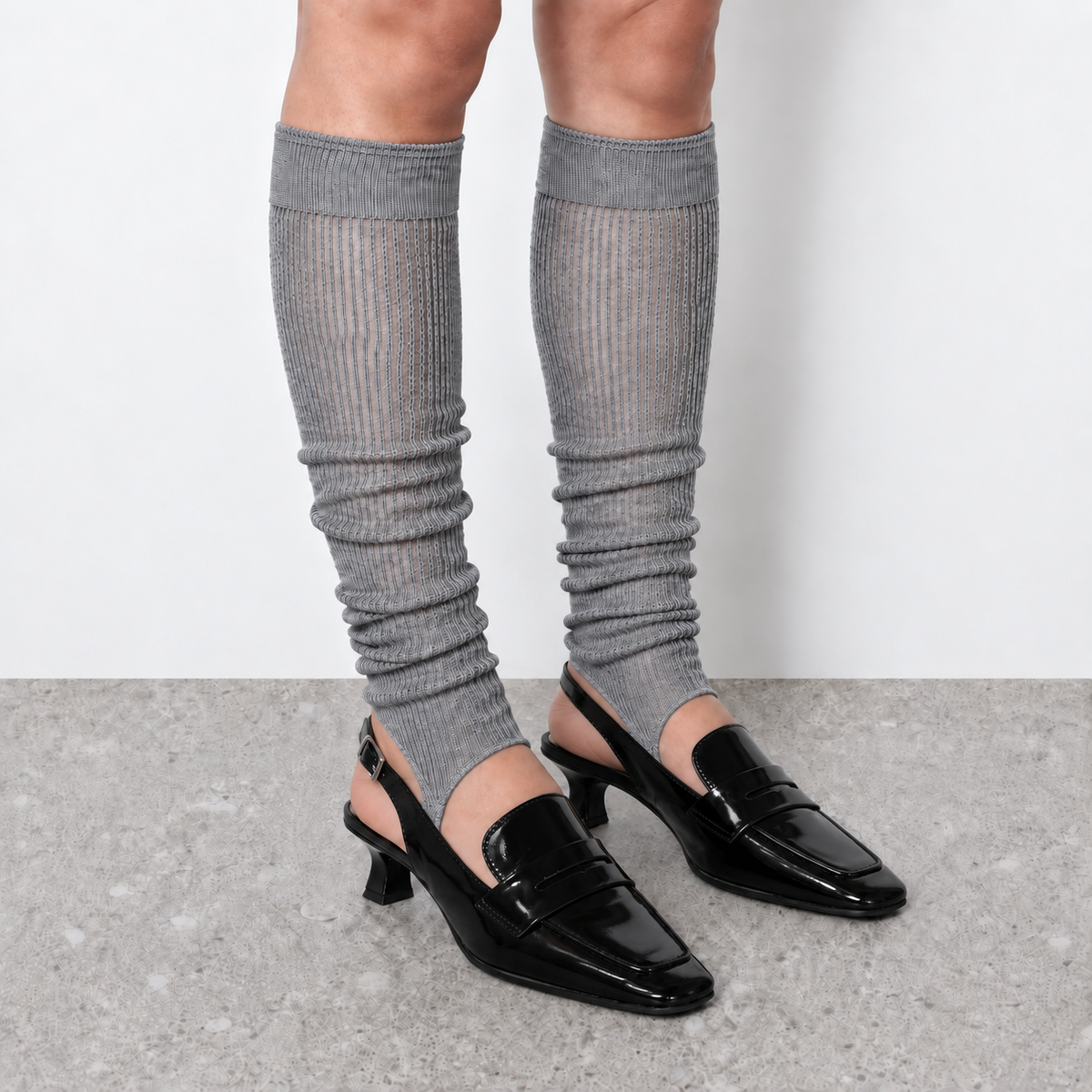 Model wearing grey ruched stirrup leg warmers over slingback heels seen from the front