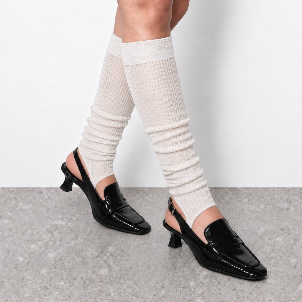 Model wearing white ruched stirrup leg warmers over slingback heels seen from the side
