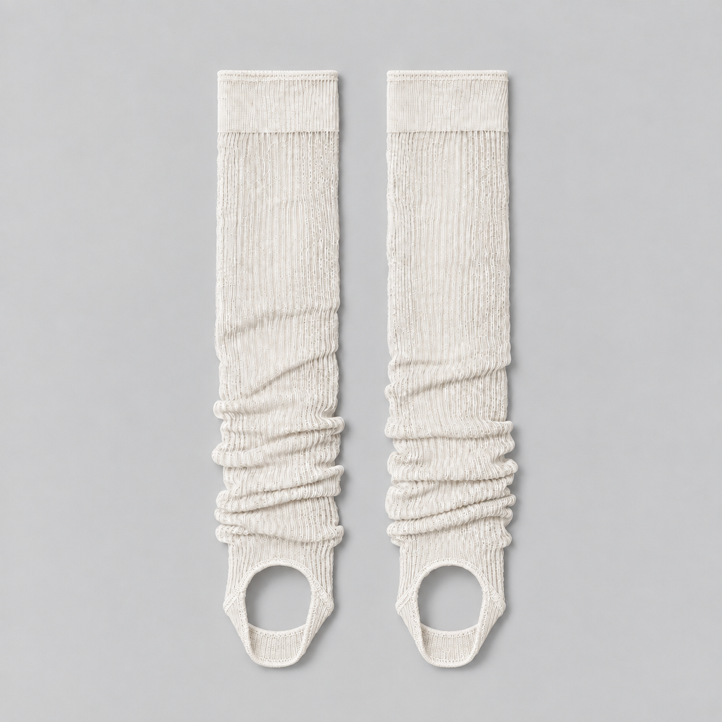 white ruched stirrup leg warmers laid flat on a pale background