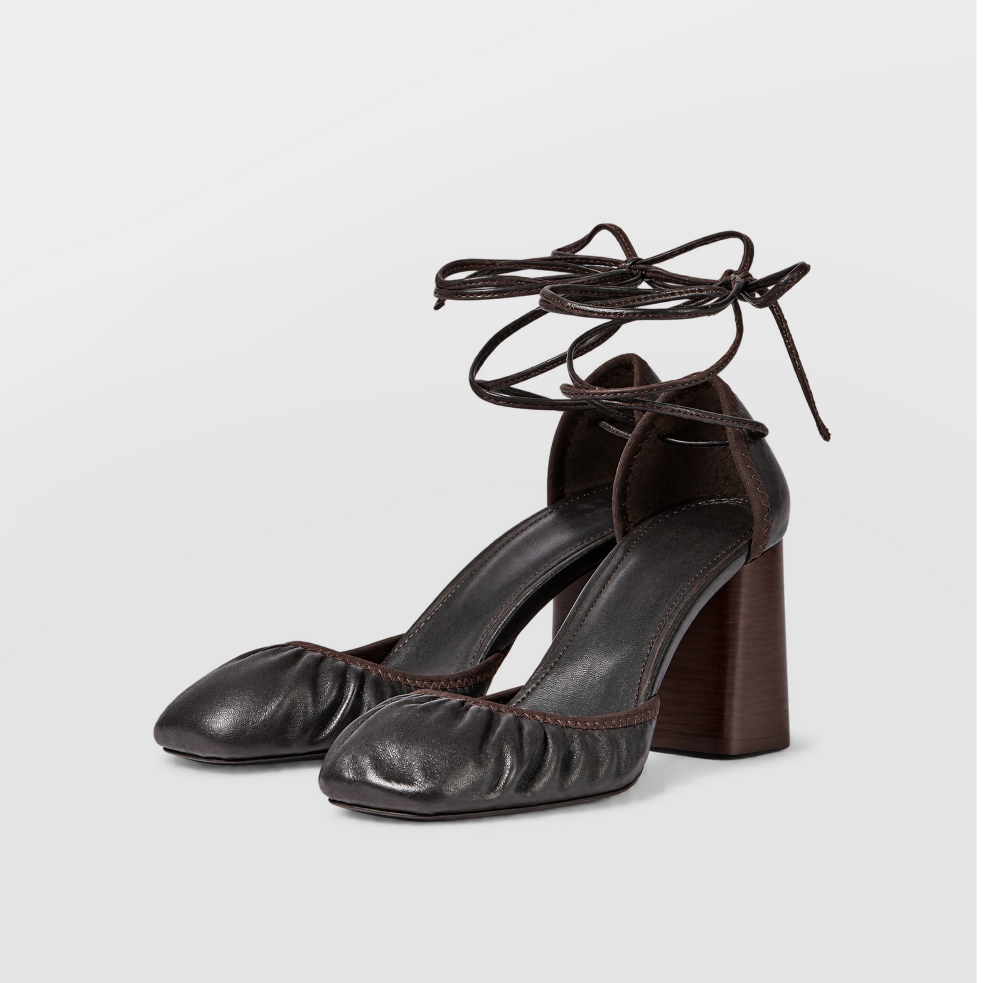 Front view of brown block heel pumps showing the closed round toe