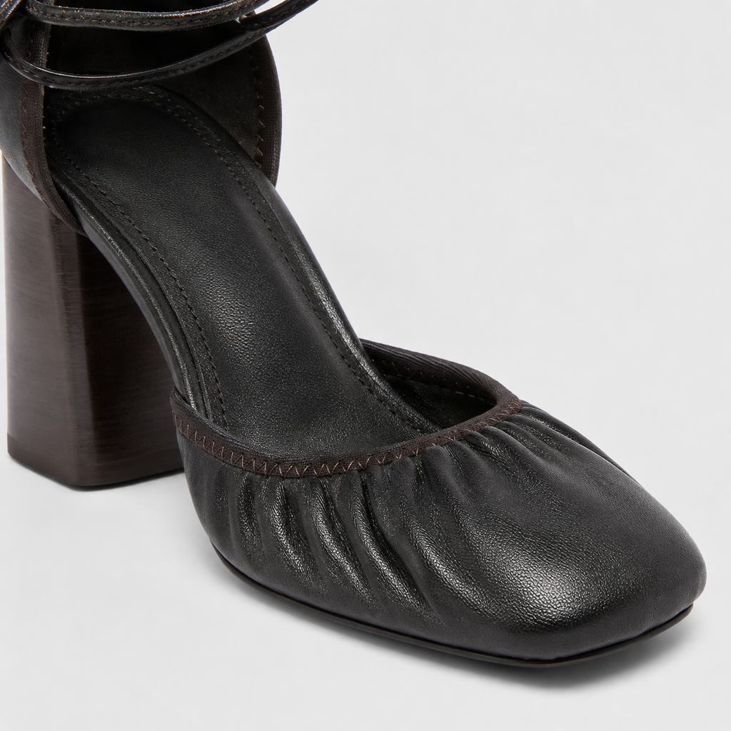 Side profile on foot of brown block heels worn with a long draped skirt