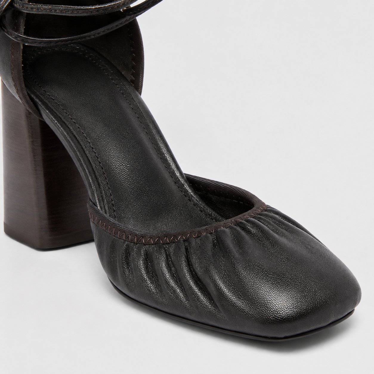 Side profile on foot of brown block heels worn with a long draped skirt
