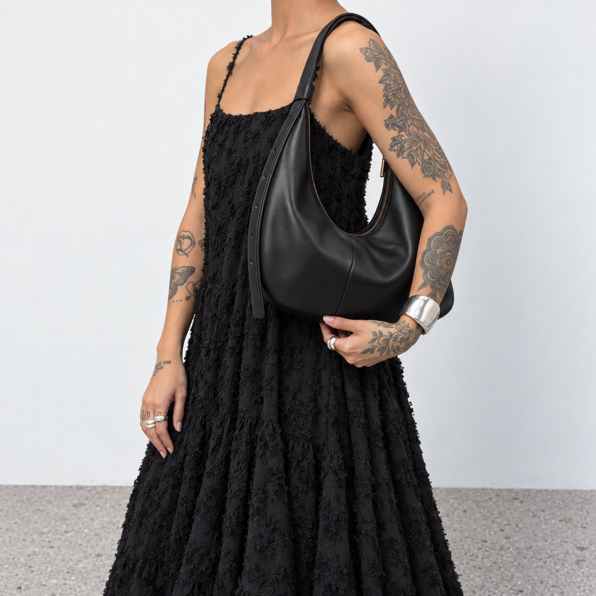 Model carrying the black Solea crescent shoulder bag under the arm