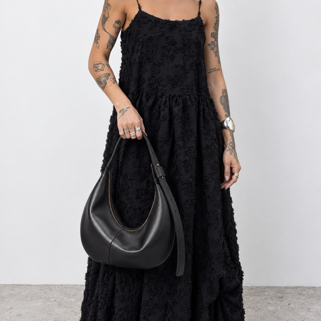 Model wearing the curved half-moon bag over one shoulder