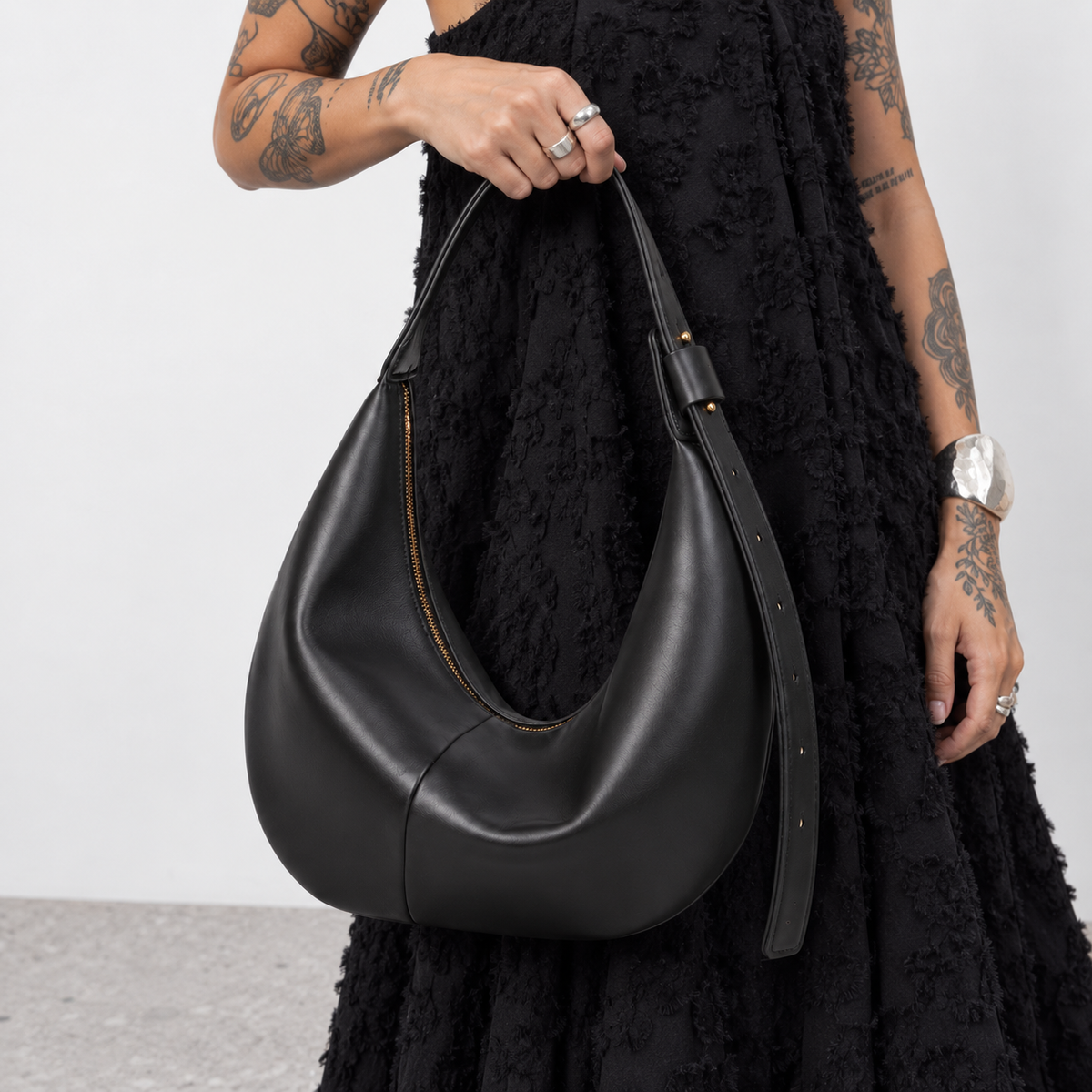 Close view of the black crescent bag held against a black outfit