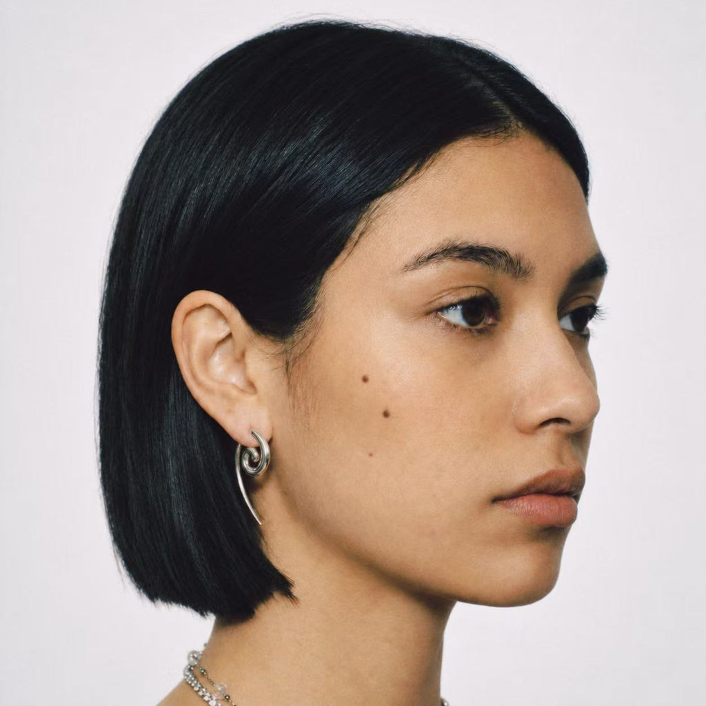 Model wearing the Spiral Coil Drop Earrings seen from the front