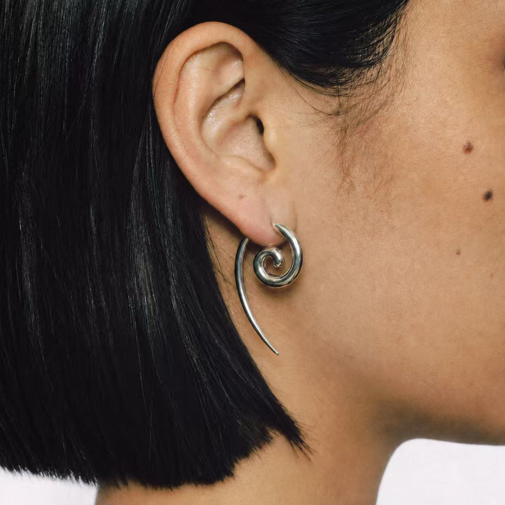Model wearing the Spiral Coil Drop Earrings seen from the side