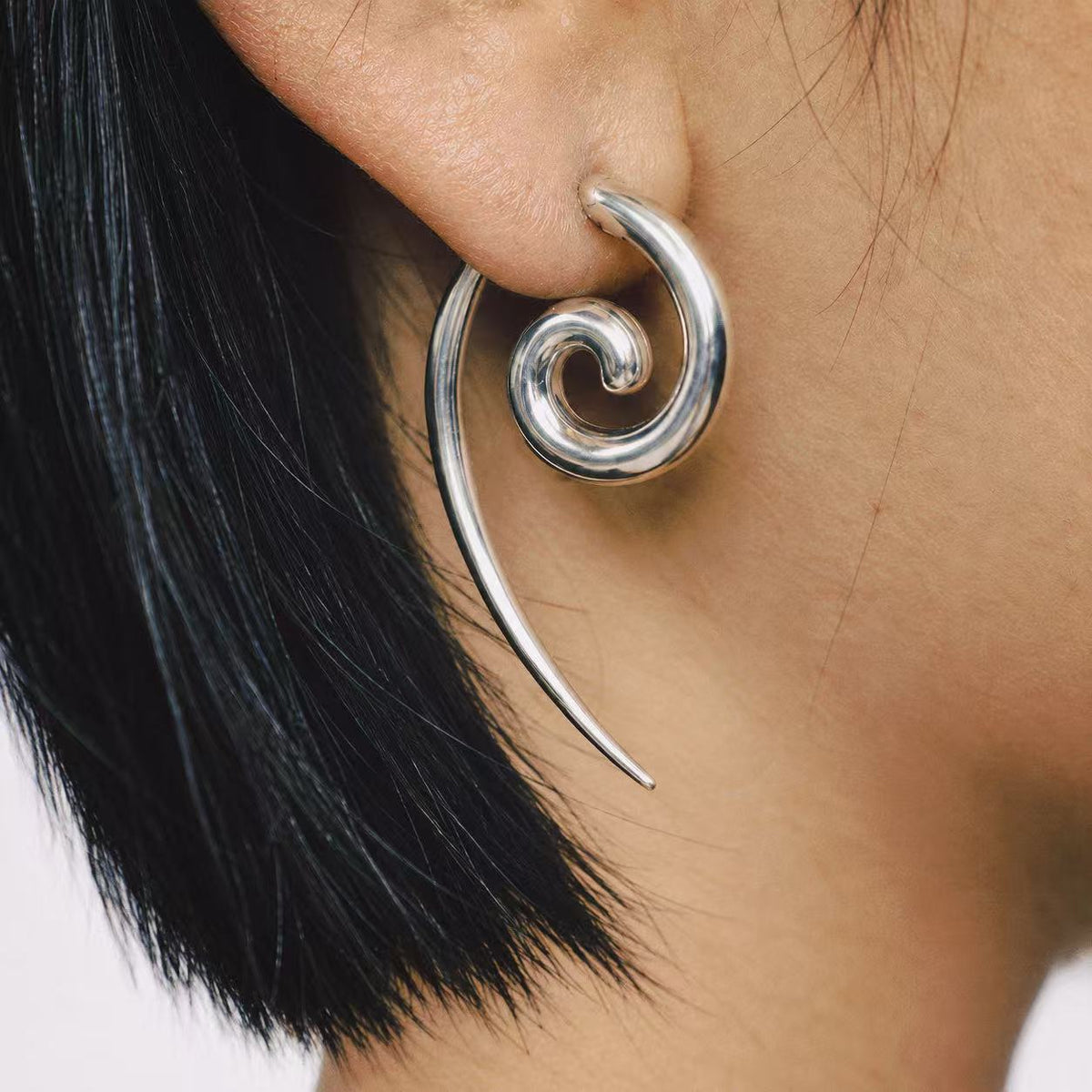 Model wearing the Spiral Coil Drop Earrings in a close crop