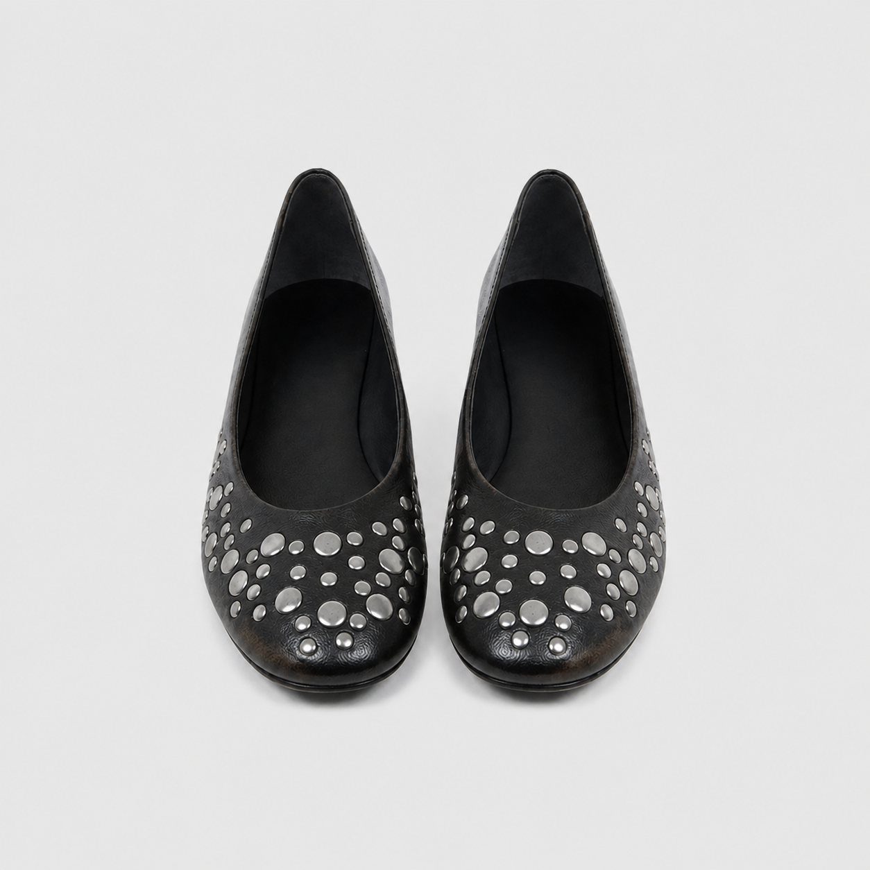 Top down view of studded ballet flats with burnished toes and deep unbroken topline