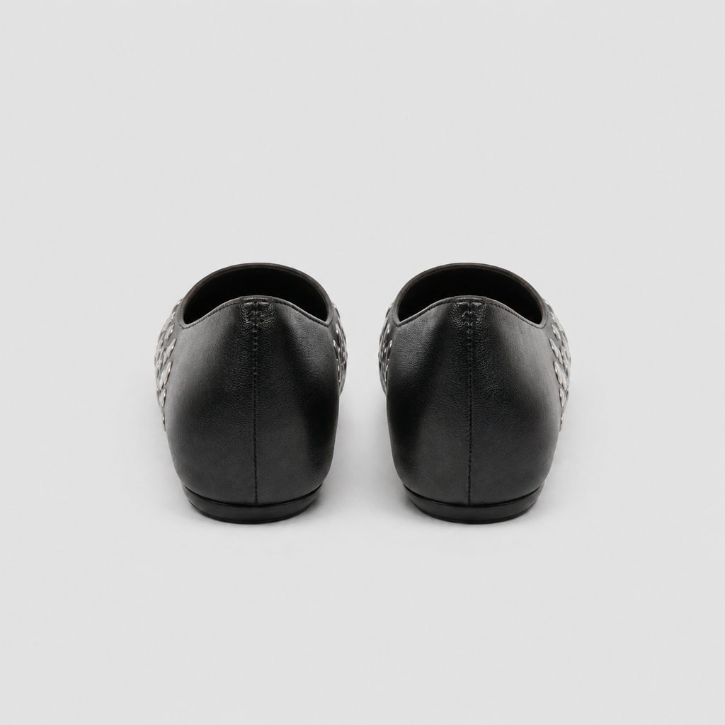 Rear view of black studded ballet flats showing plain heels and low wedged soles