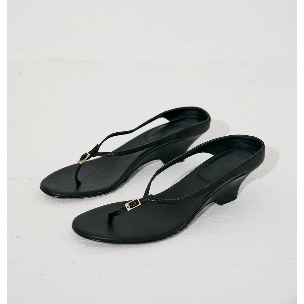 Black strappy sandals with wedge heel, side view on white background by lil cacti