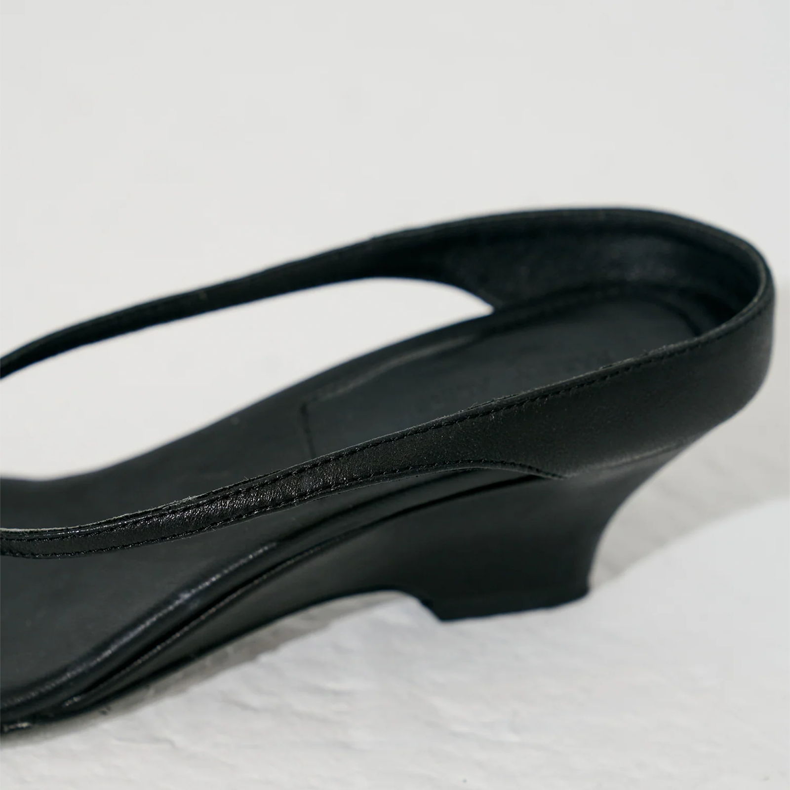 Thong sandals with wedge sole in black leather — metal ring detail close-up by lil cacti

