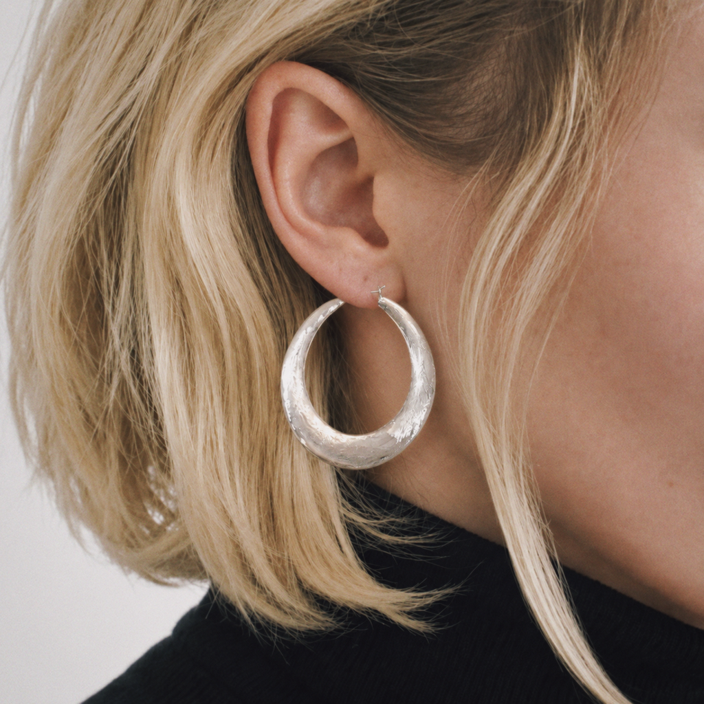 Model wearing Tide Hammered Hoop Earrings by Lil Cacti, view 1