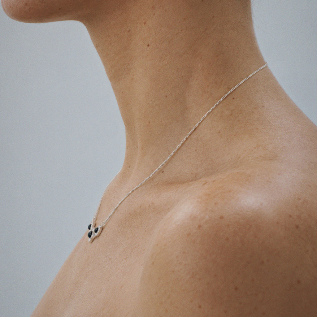 Model wearing the Triad Art Deco Station Necklace in soft daylight