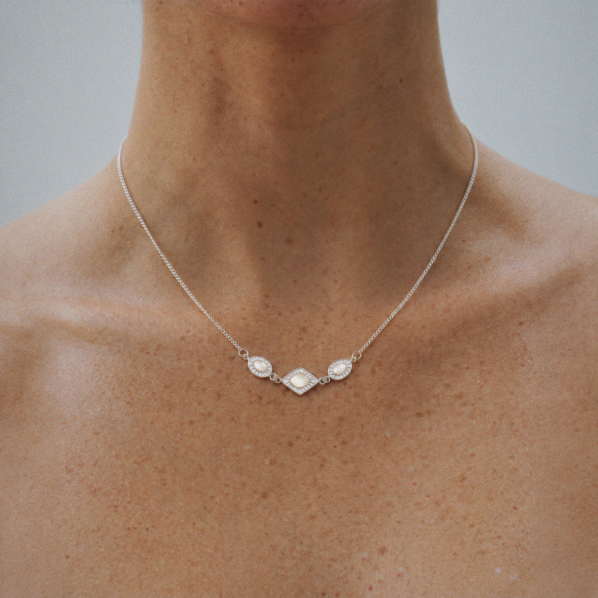 Model wearing the Triad Art Deco Station Necklace with hair swept back
