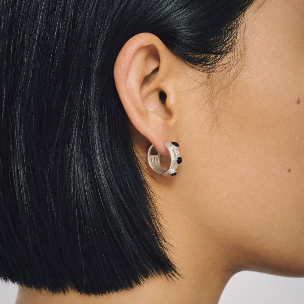 Model wearing the Vault Black Stone Hoop Earrings from a side angle