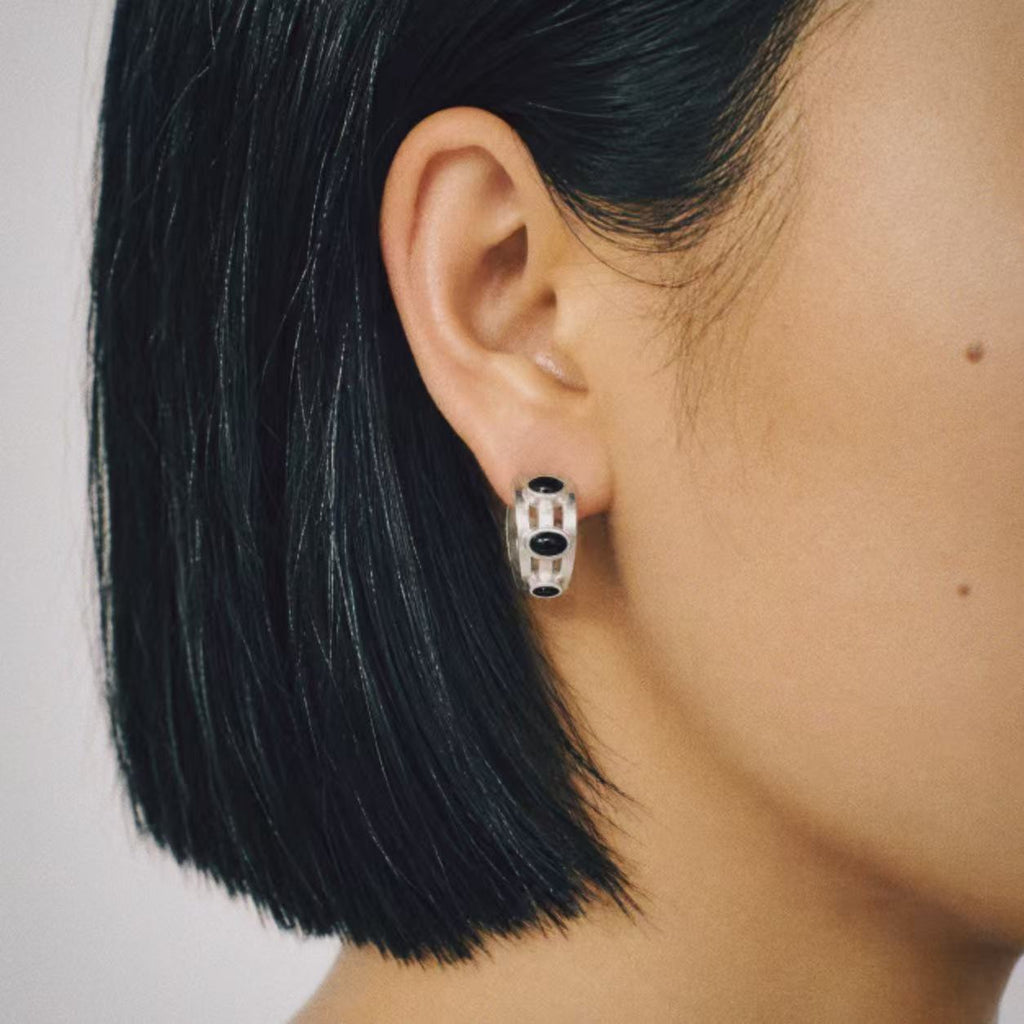 Model wearing the Vault Black Stone Hoop Earrings, three quarter view