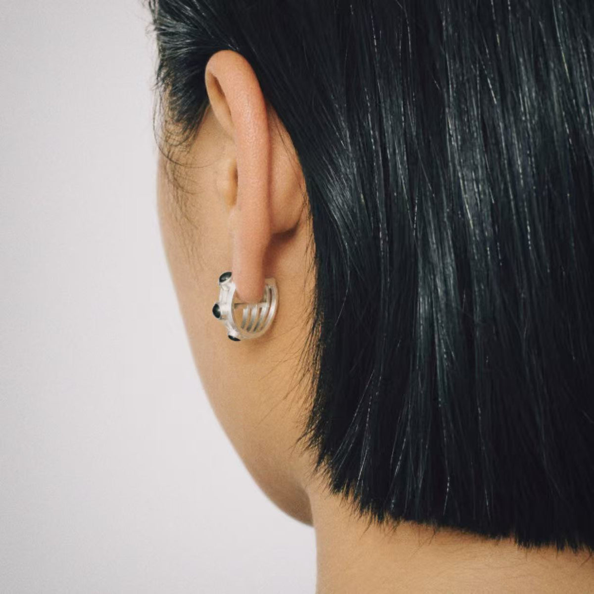 Model wearing the Vault Black Stone Hoop Earrings in soft daylight