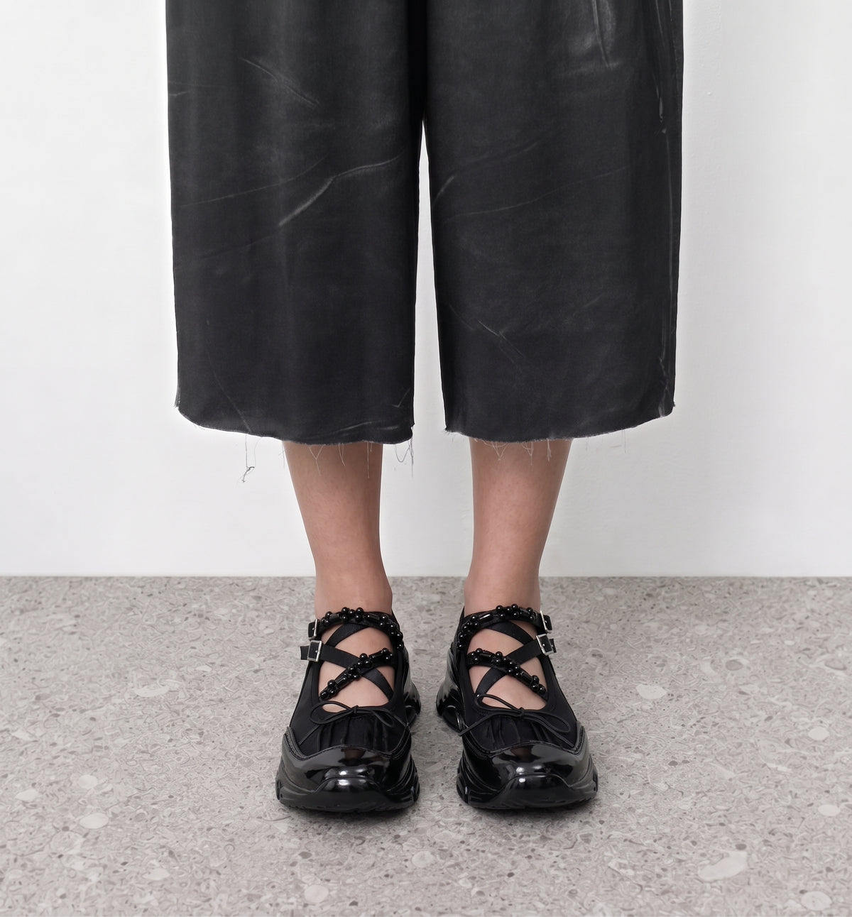 Velvet Barre Ballet Sneakers by Lil Cacti — front view on model, crossed bead straps and bows above the patent toes