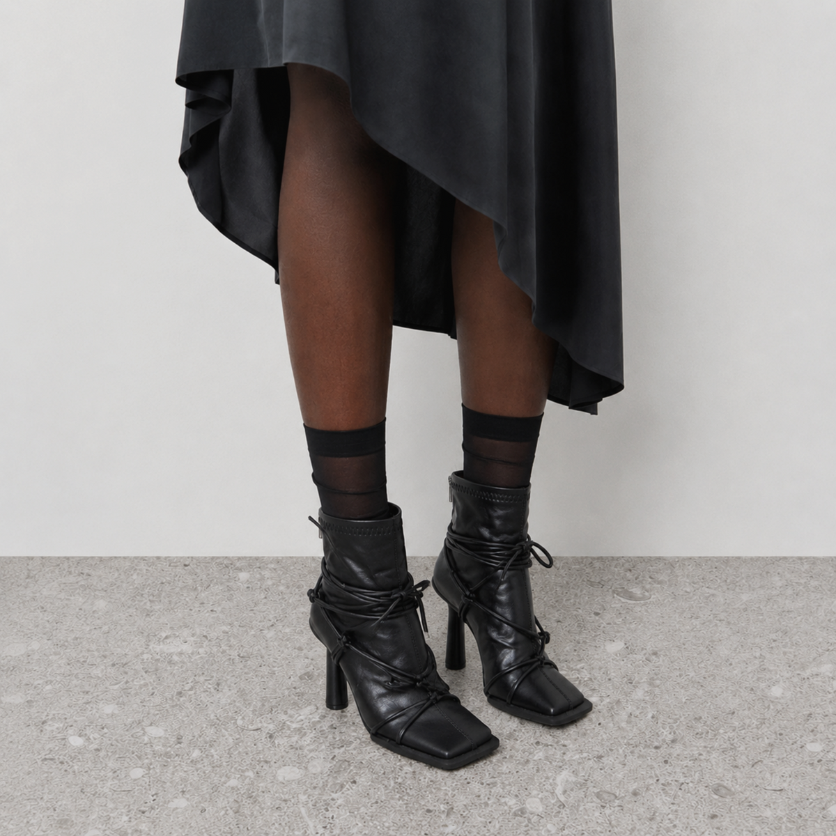Verity Lace-Up Square Toe Boots by Lil Cacti — on-model three-quarter view with sheer black socks and a black midi skirt