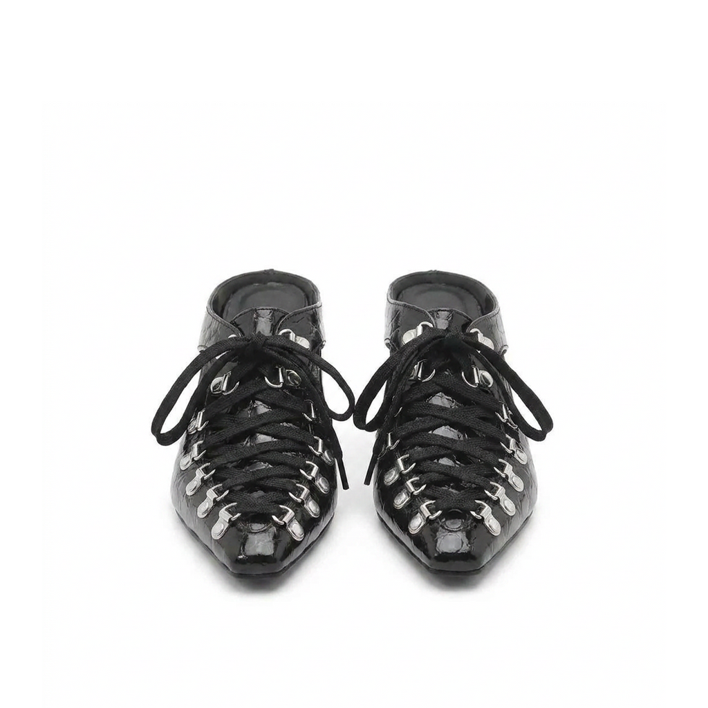 Close-up of sculptural cutout heel on Vex patent mules
