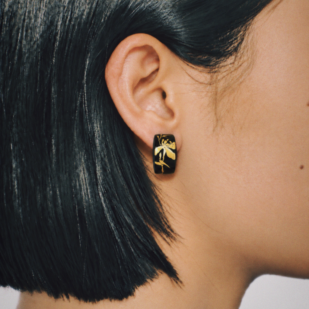 Black rectangular floral earrings shown worn with gold-tone iris details