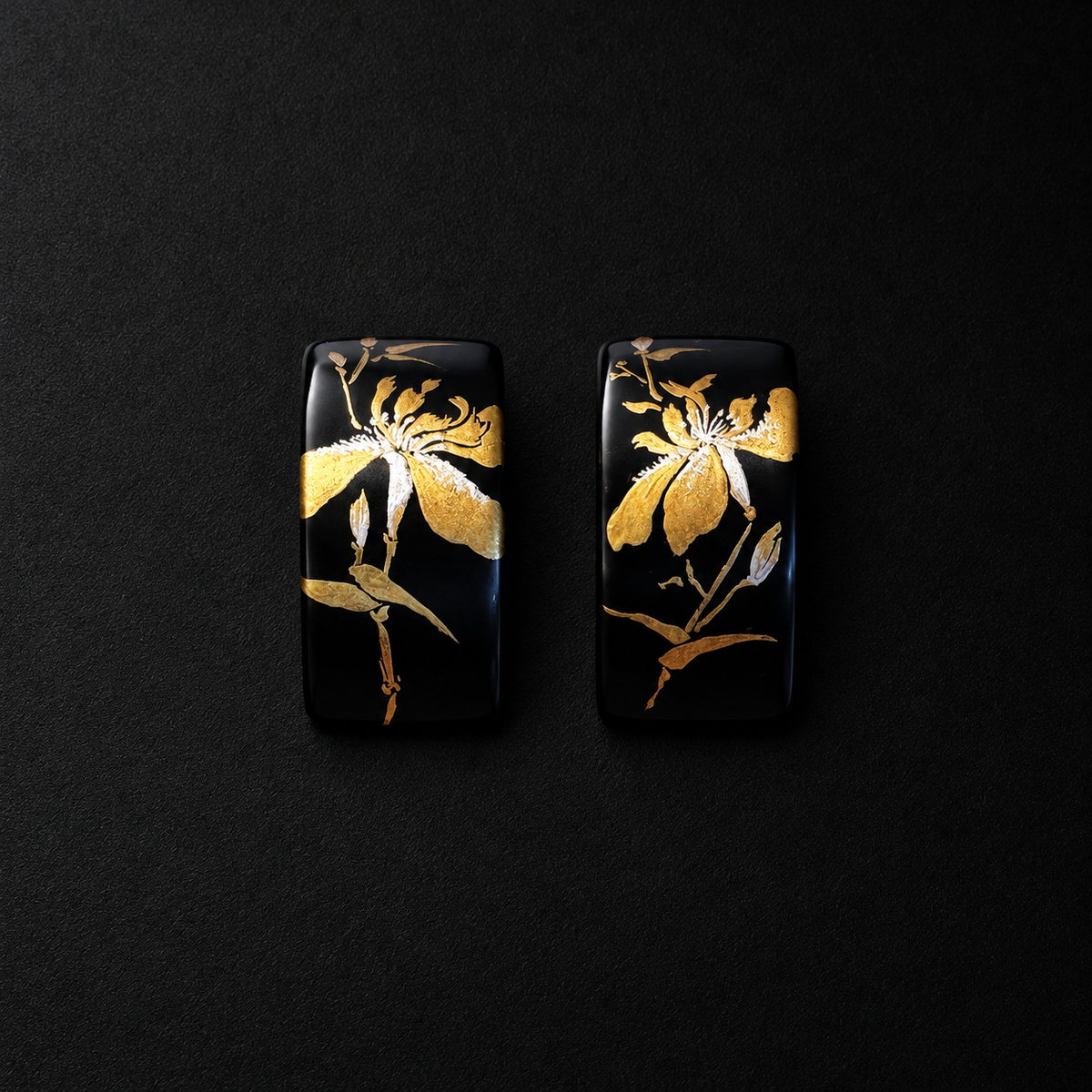 Pair of black rectangular earrings featuring gold-tone iris flower motifs