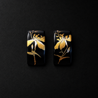 Pair of black rectangular earrings featuring gold-tone iris flower motifs