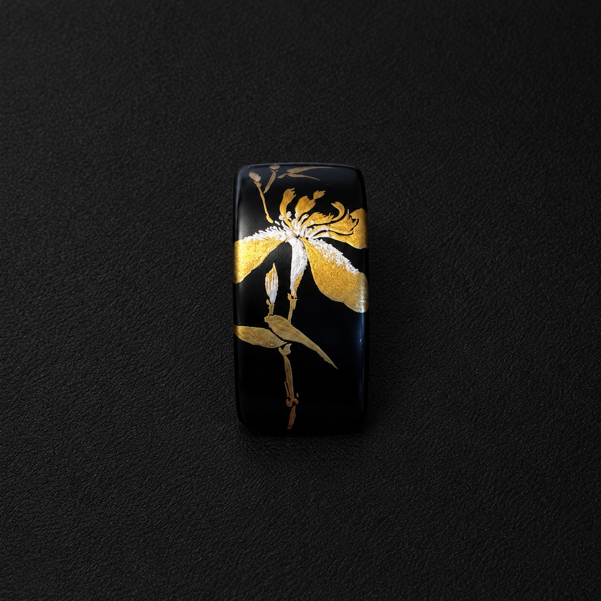 Black curved rectangle earring showing a gold-tone iris and stem