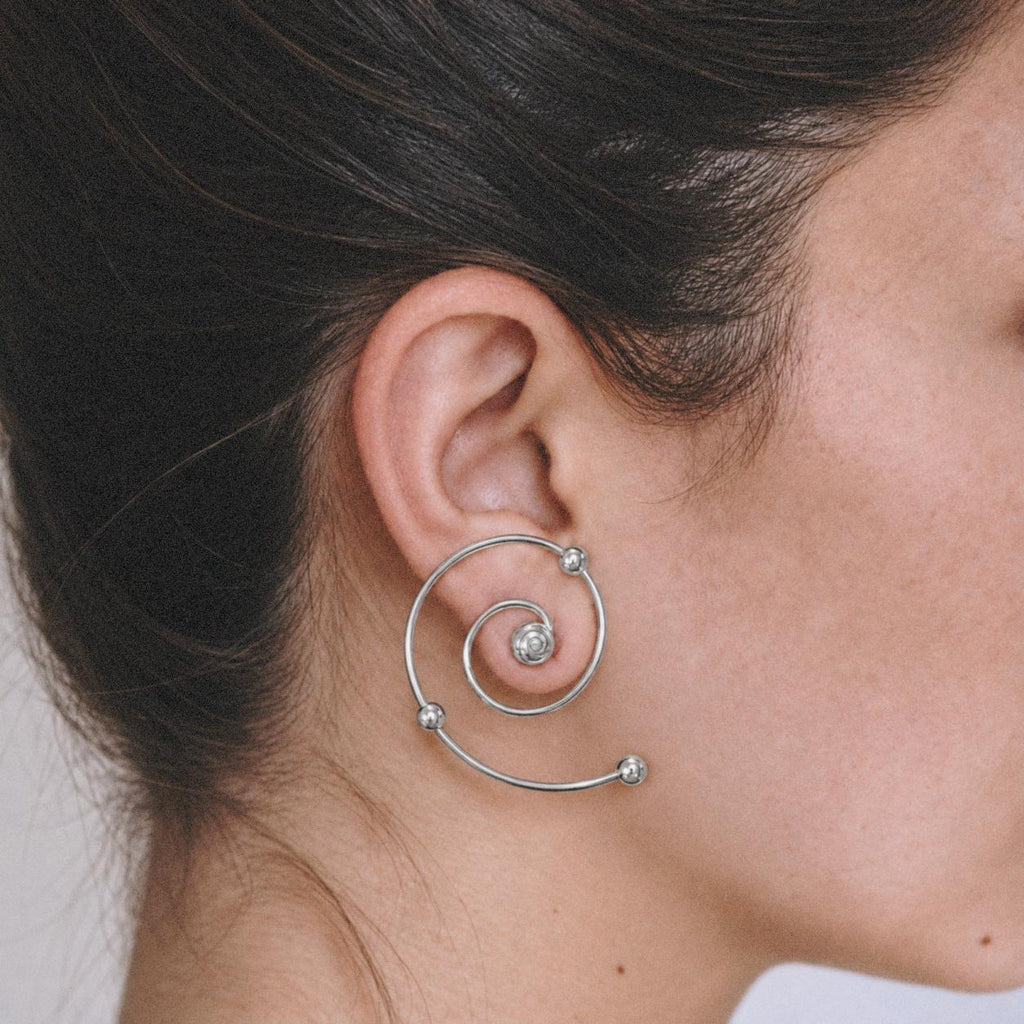 Side profile of a model wearing silver Wire Spiral Ear Climbers