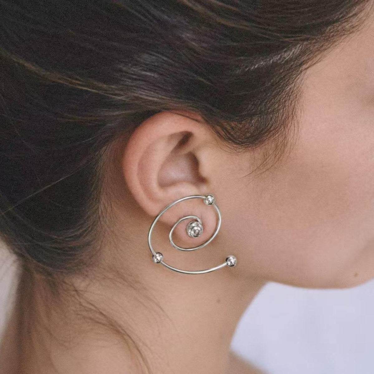 Model with hair tucked back showing the Wire Spiral Ear Climbers