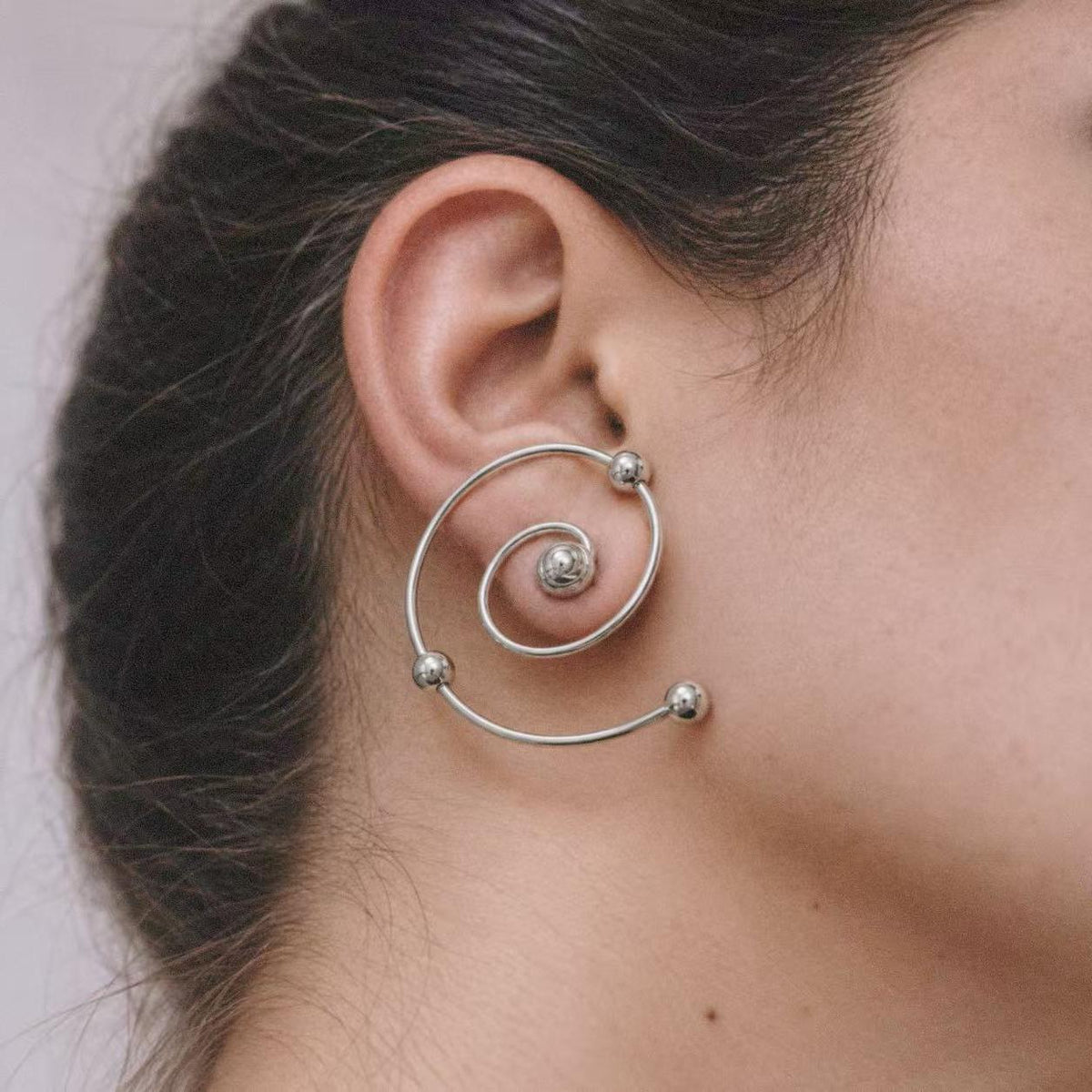 Three quarter view of a model wearing the Wire Spiral Ear Climbers