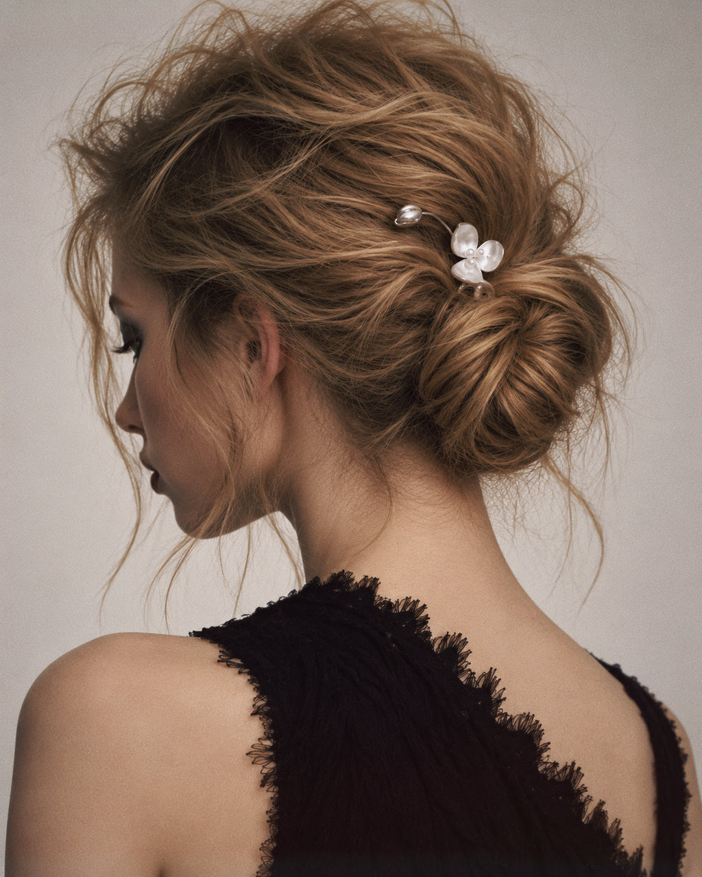 Wisp Orchid French Hair Pin styled in a low bun with a plain black outfit