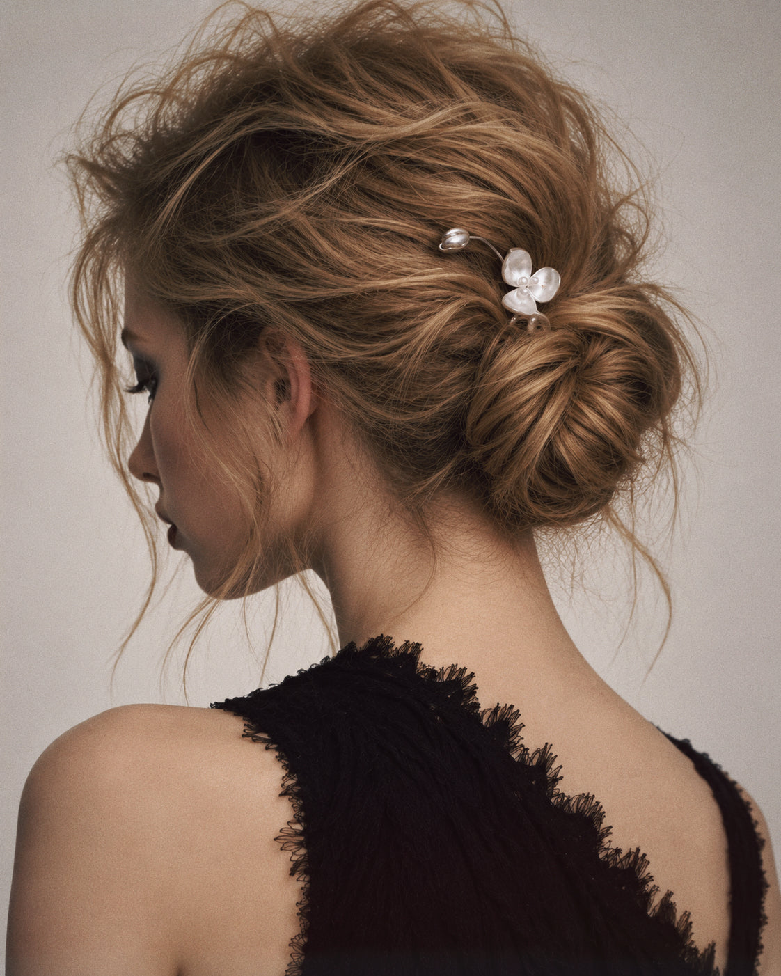Wisp Orchid French Hair Pin styled in a low bun with a plain black outfit